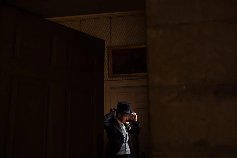 Groom putting on top hat. Fine art wedding photography, Yorkshir groom putting on top hat fine art wedding photography yorkshire