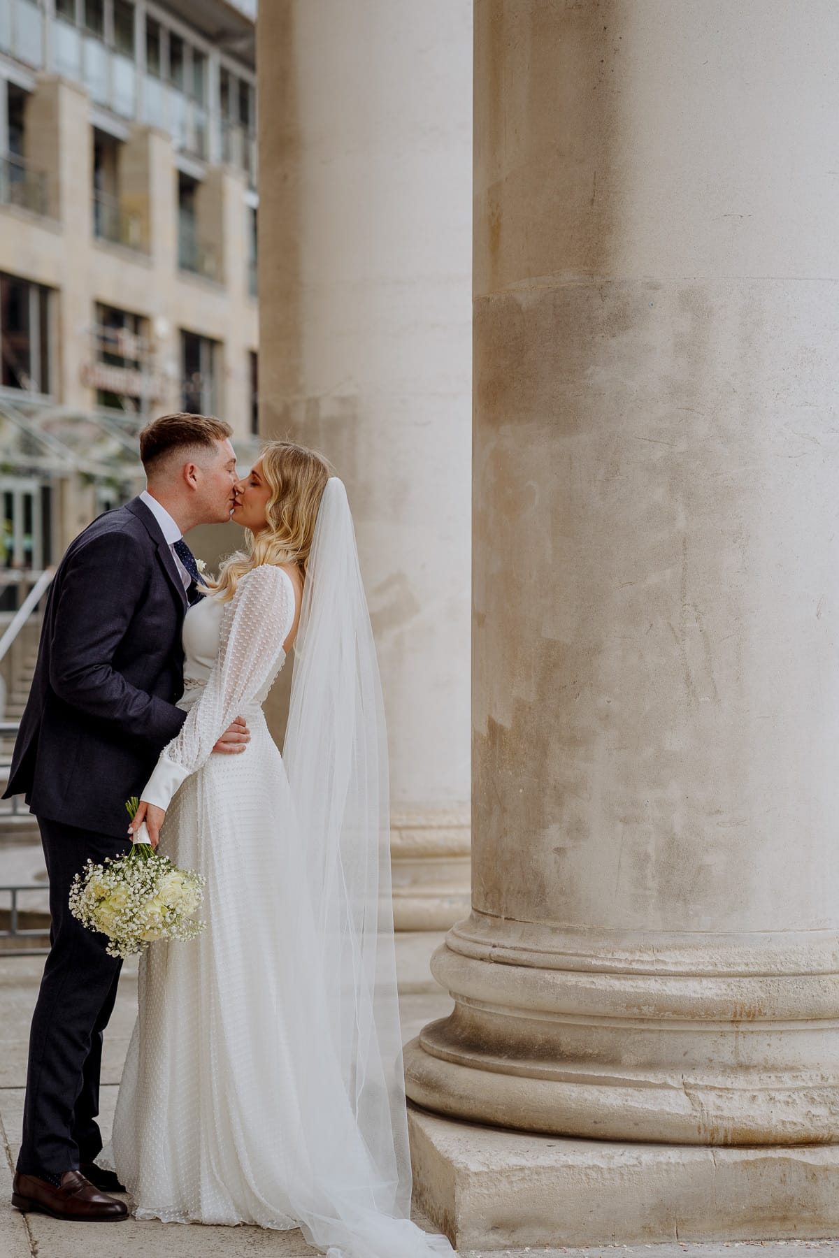 bride and groom kissing outside leeds civic hall