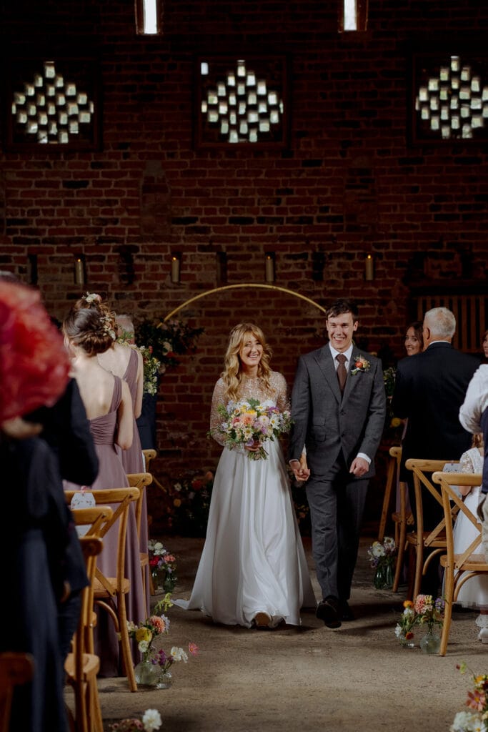bride and groom walk down the aisle after their wedding at lodge farm barn
